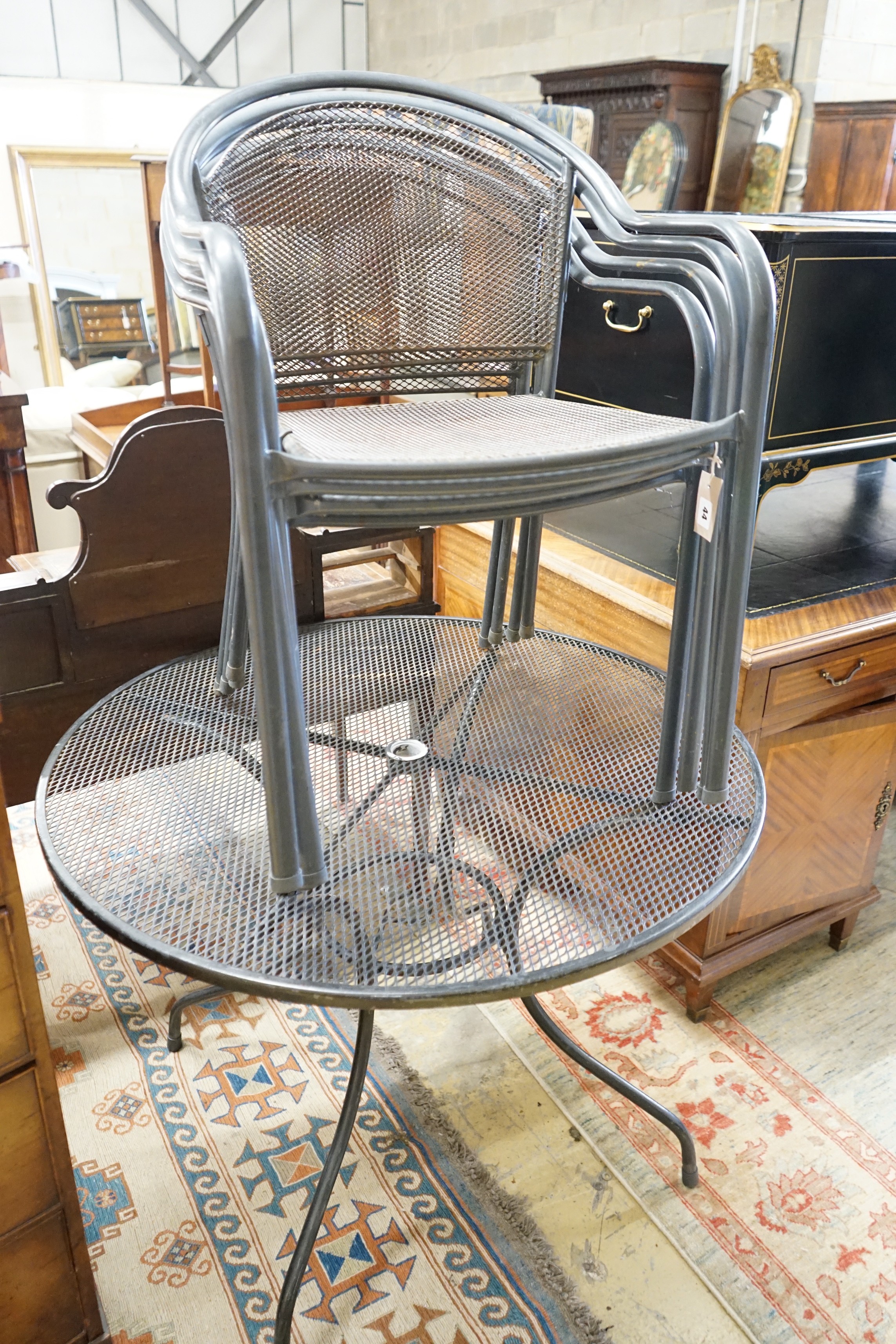 A circular aluminium garden table, diameter 100cm, height 72cm and four matching stacking chairs